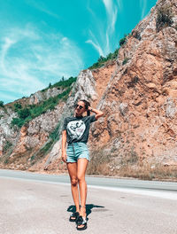 Full length portrait of woman standing on road