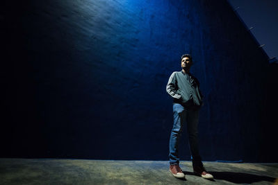 Portrait of young man standing on wall