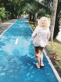 Rear view of woman walking in swimming pool