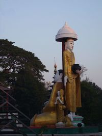 Low angle view of a man sitting against clear sky