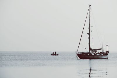 Sailboat sailing on sea against clear sky