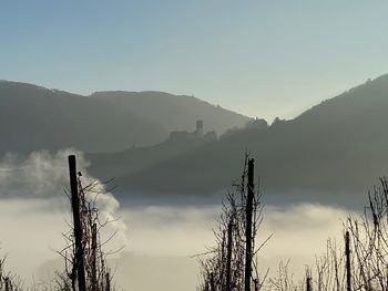 Silhouette plants and mountains against sky