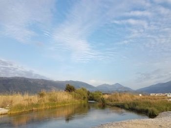 Scenic view of lake by mountains against sky