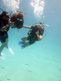 Friends gesturing while scuba diving undersea