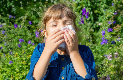 Sick girl having allergy wiping nose