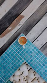 High angle view of cup of coffee over swimming pool 