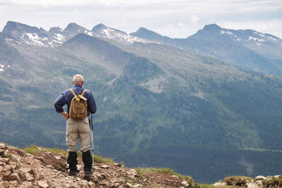 Rear view of hiker standing on mountain