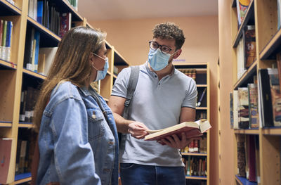 Young man reading book in library