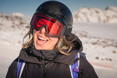 Portrait of a woman in the alps. smiling young woman in ski goggles and helmet stopped while skiing