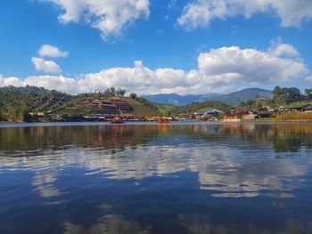 Scenic view of lake by buildings against sky