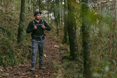 Portrait of young man standing in forest