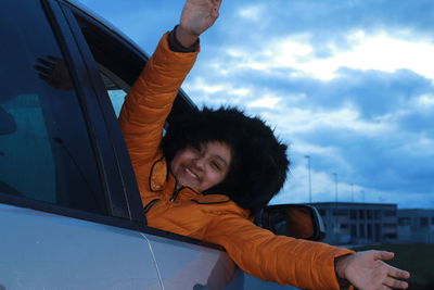 Portrait of cute girl in car against sky