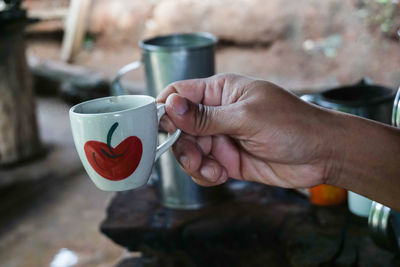 Midsection of man holding coffee cup