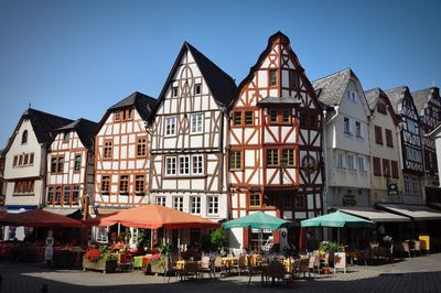 Half-timbered houses and groups of people in restaurant and cafes on main square of limburg, germany