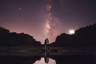 Scenic view of lake against sky at night