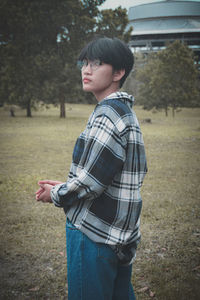 Side view of young man standing on field