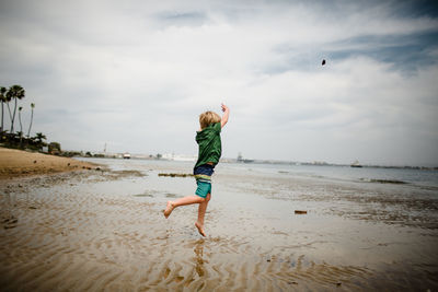 Six year old boy skipping rocks in coronado bay