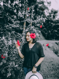 Midsection of woman standing by flowering plants