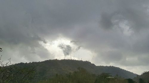 Low angle view of storm clouds over mountain