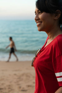 Smiling woman looking away at beach
