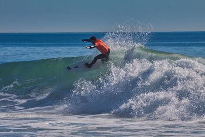 Man surfing on sea against sky