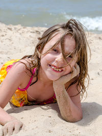 Smiling girl on a sandy beach with wind swept hair