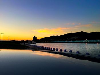 Scenic view of river against sky at sunset