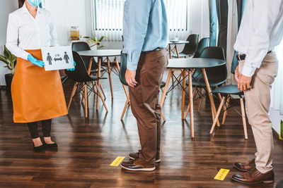 Low section of people standing on wooden floor