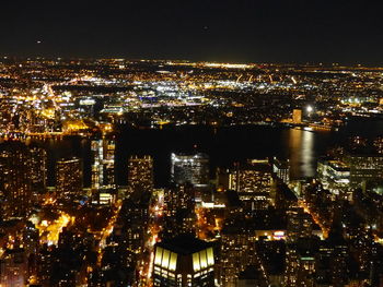 Illuminated cityscape against sky at night