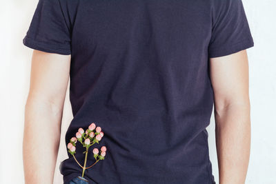 A man in a tshirt with a flower in his jeans pocket on a white background.health, wellness concept. 