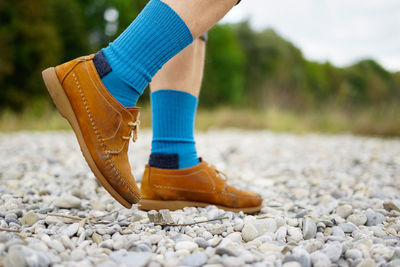 Low section of person legs on pebbles