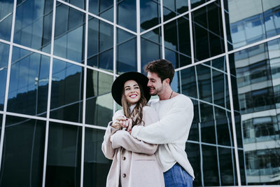 Full length of a smiling young couple standing outdoors