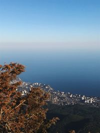 High angle shot of townscape by sea against sky