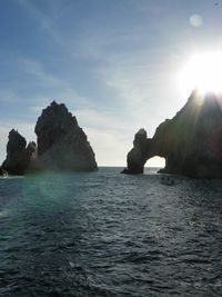 Arch of cabo san lucas and rock formation in sea against sky