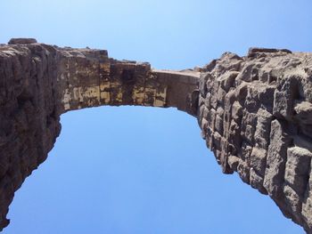 Low angle view of old ruins against clear blue sky