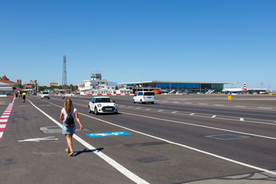 Vehicles on road against clear sky
