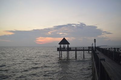 Lifeguard hut on beach against sky during sunset