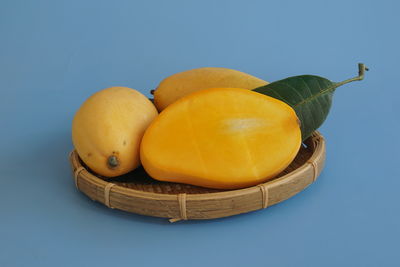 High angle view of fruits in basket against blue background
