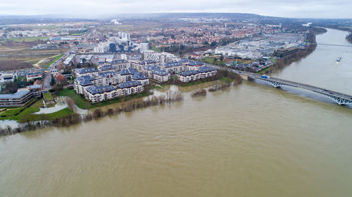 High angle view of river by town against sky