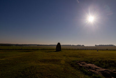 Scenic view of field against bright sun