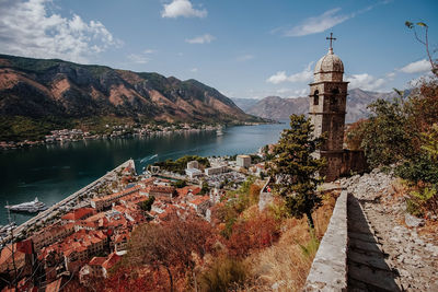 View of lake and buildings against cloudy sky