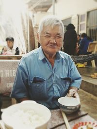 Portrait of mid adult man sitting on table