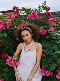 Portrait of young woman standing amidst flowers