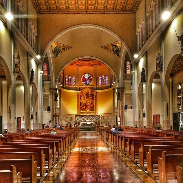 indoors, place of worship, arch, religion, architecture, spirituality, illuminated, built structure, lighting equipment, ceiling, church, in a row, empty, architectural column, corridor, pew, interior, the way forward