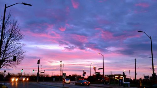 Traffic on road against dramatic sky