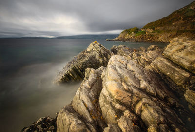 Scenic view of rocks in sea against sky