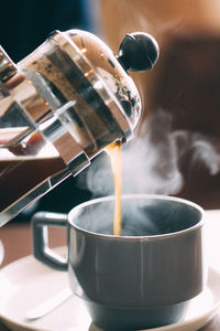 Close-up of pouring coffee in cup