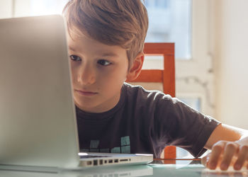 Boy using laptop at home