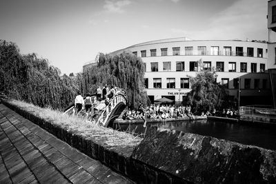 People by river against sky