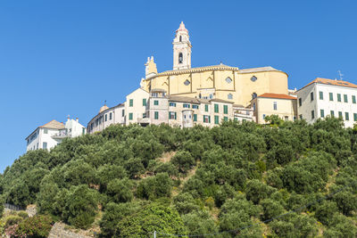 View of trees and buildings against blue sky